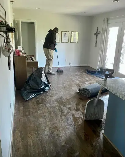 Cleanup of mud and water from a hardwood hallway after flooding