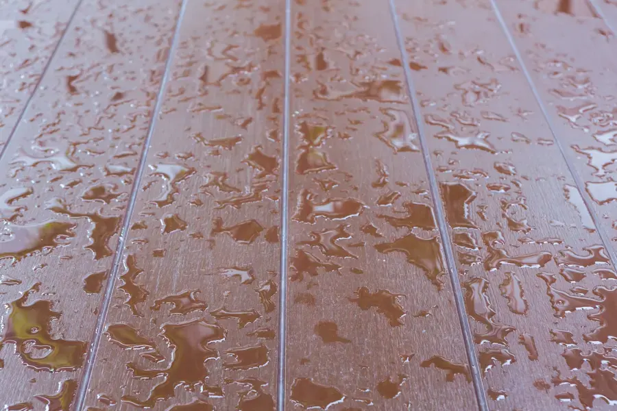 Standing water droplets on a laminate floor from a hidden leak